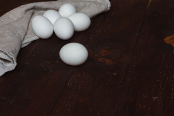 White chicken eggs on a brown wooden table