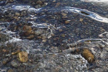Natural background, the stones at the bottom of the creek. Clean stream.