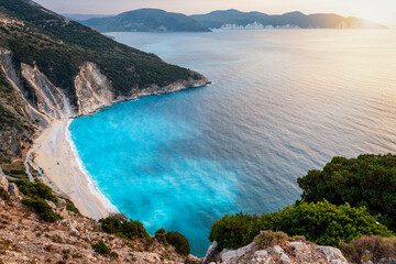The popular Myrtos beach on the Greek island of Kefalonia, Ionian Sea, during sunset with fluorescent, blue sea