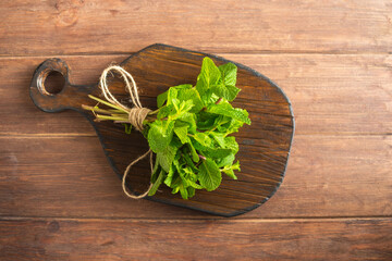 Fresh green mint leaves close-up on a wooden dark background. Mentha piperita plant.