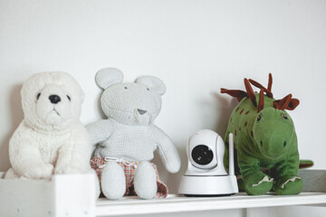 IP camera on the shelf with toys, serving as baby monitor