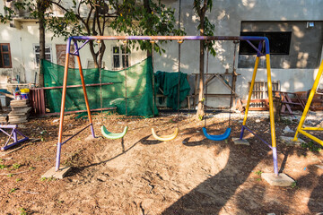 Fototapeta na wymiar Empty swing with chains on the playground