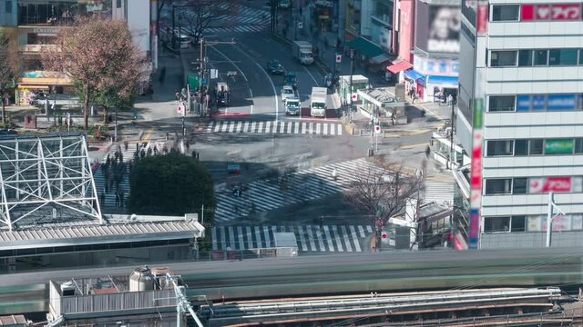 4K Aerial time lapse view over Shibuya crossing with many pedestrians and vehicles crossing the junction, blurred logos
