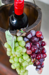 Oakwood wine basket with red and white grape with wine bottle inside. Food and beverage concept