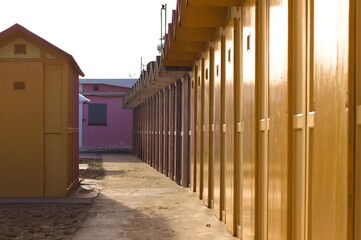 A series of yellow beach huts in a bathing establishment on the Mediterranean coast (Pesaro, Italy, Europe)