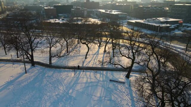 aerial drone establishing shot footage of Chicago downtown area during the winter time early in the morning after sunrise.  the white snow covers most of the city architecture landscape.   
