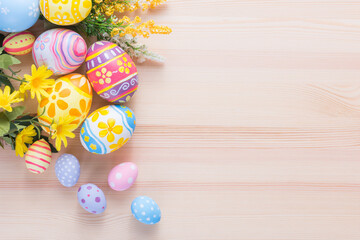 Happy Easter day colorful eggs and flower decoration on wood background with copy space