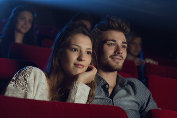 Young loving couple at the cinema - obrazy, fototapety, plakaty