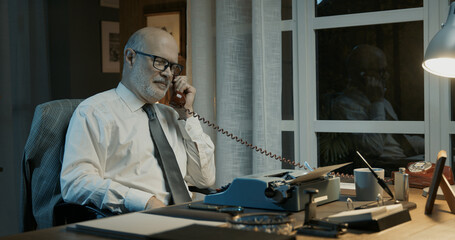 Professor sitting at desk and having a phone call