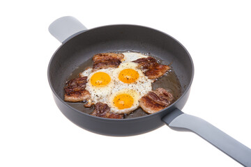 fried eggs with bacon in a frying pan isolated