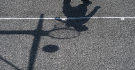 Shadow of a man play basketball. Street basketball court. Sport team concept