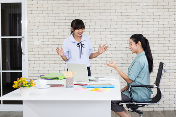 Asian women teach sign language for use in work to young girls. Using sign language and wearing medical masks at work can help reduce the spread of the Covid virus.