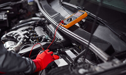 Mechanic checking voltage of car battery