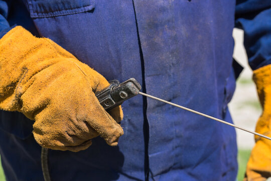 Profession welder, working specialty, equipment tool for welding metals electrode holder in the hands of a man at work, employment and labor