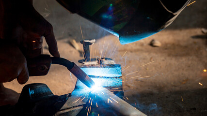 Welding of steel, sparking, not wearing gloves, light colored like fireworks.