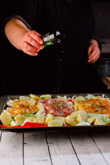 cook marinating the chicken thigh in the oven. Top view. on a baking sheet.