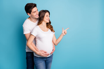 Fototapeta premium Photo of young happy positive good mood couple look point finger copyspace isolated on blue color background