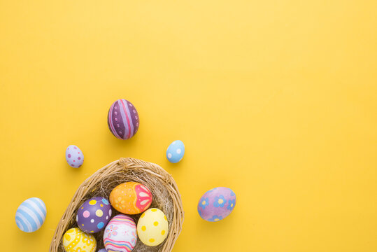 Happy Easter day decoration colorful eggs in nest on paper background with copy space