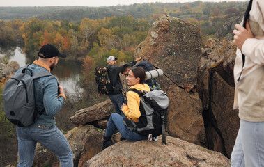 Group of hikers with backpacks climbing down mountain