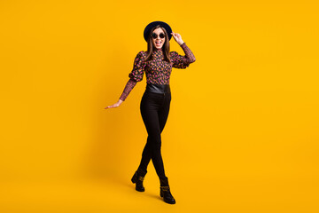 Fototapeta na wymiar Full length body size photo of cheerful woman in stylish trendy clothes sunglass black cap boots isolated bright yellow color background
