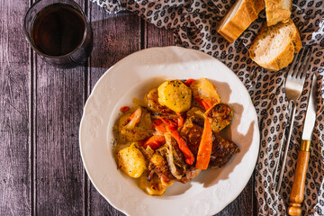 white plate with baked chicken thigh. Top view.