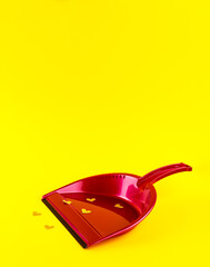 Pink dust pan with shiny golden Heart shape stickers on yellow background.