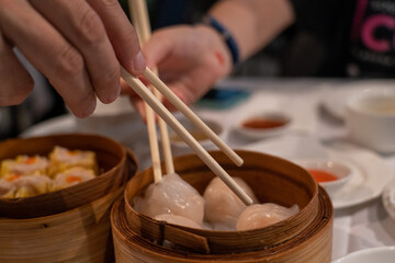 Fototapeta na wymiar Steamed dumplings in bamboo steamer in yum cha Chinese restaurant 