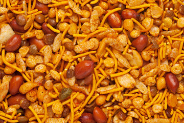 Hot spicy NavRatan mixture  snacks in full-frame, made with, potato chips, peanuts, besan sev, red chili. Pile of Indian spicy snacks (Namkeen), Top  view.