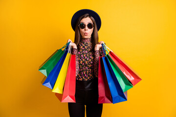 Portraitf of shocked person hold bags lips staring dark headwear retro clothing isolated on yellow...