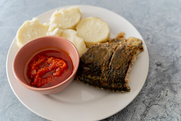 Nigerian boiled yam served with Grilled fish and tomato pepper sauce