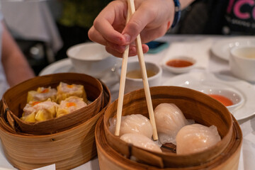 Steamed dumplings in bamboo steamer in yum cha Chinese restaurant
