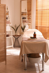 Beautiful spa accessories on massage table in room