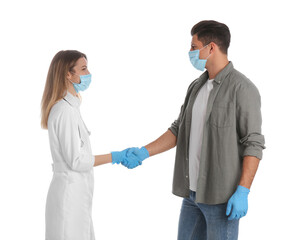 Fototapeta premium Doctor and patient in protective masks shaking hands on white background