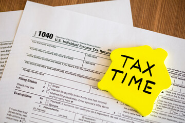 Tax time concepts. 1040 tax form on wooden table with pen and calculator