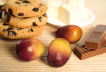 Naklejka na ściany i meble Palm oil fruits and sweets on wooden table, closeup