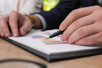 Business people working with documents at table in office, closeup. Investment analysis