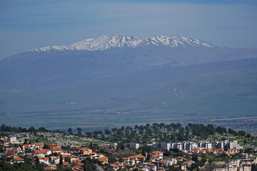 Aerial view of the Rosh Pina village against the snowcapped mount Hermon in Israel
