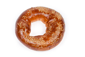 Ring shaped bread roll sprinkled with sesame on white background