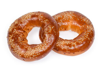 Ring shaped bread rolls sprinkled with sesame on white background