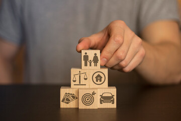 Business and finance concept. Hand holds wooden Wooden blocks with finance icons. securities, securities, money, idea, bitcoin, coins, gold on background human