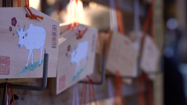 Slow tracking typical wooden wishing cards at Japanese shrine low depth of field