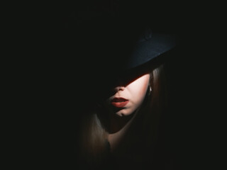 Woman with hat in the dark