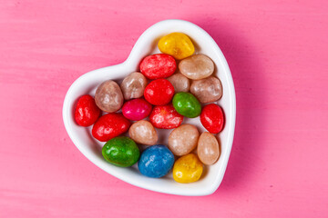 Multicolored candies in a plate in the shape of a heart