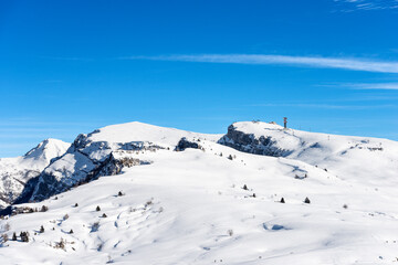 Fototapeta na wymiar Peak of Malga San Giorgio Ski Resort in winter with snow. Altopiano della Lessinia (Lessinia Plateau), Regional Natural Park, Verona province, Veneto, Italy, Europe. On the left the Monte Carega.