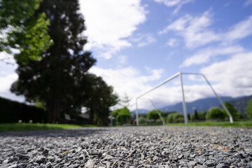 close-up of foreground gravel path with playing field in background