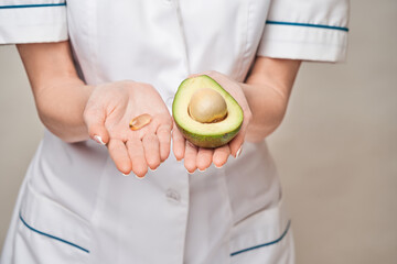 Health care and diet concept - doctor nutritionist or cardiologist holding fish oil in capsules for...