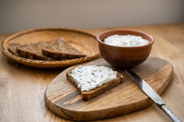 Fototapeta na wymiar Homemade Crispbread toast with Cottage Cheese and parsley on wooden board