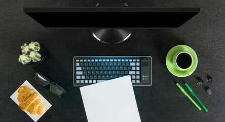 Big black computer screen on a black table with stationary items, working place