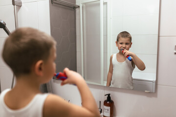little boy brushing his teeth in bathroom
