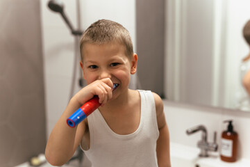 little boy brushing his teeth in bathroom